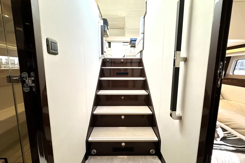 Highland Patriot Yacht Photos Pics Staircase inside 2023 Prestige 590 yacht, featuring modern design and luxurious interior.