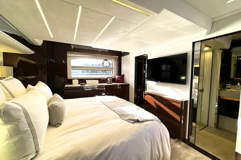 Highland Patriot Yacht Photos Pics Luxurious bedroom interior of 2023 Prestige 590 yacht with modern decor and large TV.
