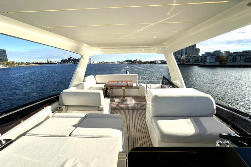 Highland Patriot Yacht Photos Pics Luxurious 2023 Prestige 590 yacht interior with elegant seating and scenic waterfront view.