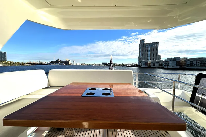 Highland Patriot Yacht Photos Pics Luxurious 2023 Prestige 590 yacht deck with cityscape and waterfront views.
