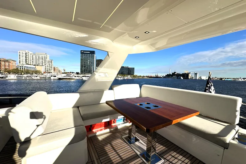 Highland Patriot Yacht Photos Pics Luxurious 2023 Prestige 590 yacht interior with waterfront cityscape view.