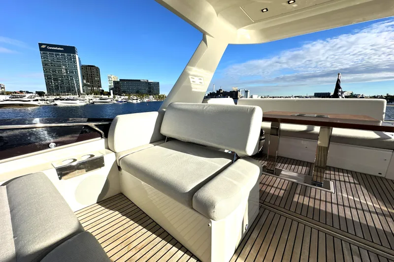 Highland Patriot Yacht Photos Pics Luxurious 2023 Prestige 590 yacht deck with modern seating and scenic waterfront view.