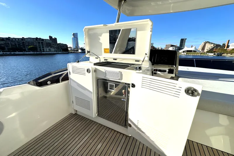 Highland Patriot Yacht Photos Pics Prestige 590 yacht outdoor kitchen area with cityscape view, 2023 model.