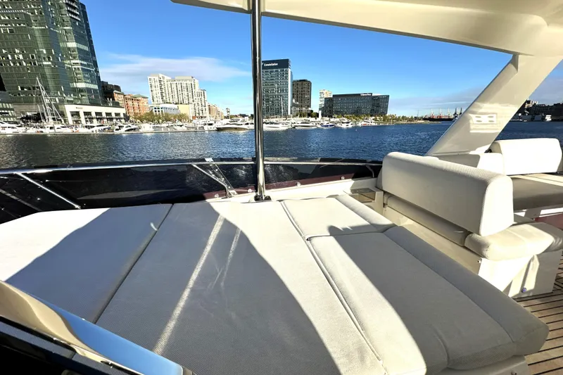 Highland Patriot Yacht Photos Pics Luxurious 2023 Prestige 590 yacht with spacious deck, city skyline view, and waterfront setting.
