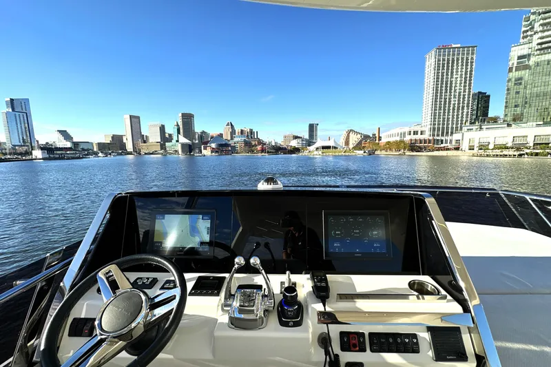 Highland Patriot Yacht Photos Pics Helm of 2023 Prestige 590 yacht overlooking city skyline and waterfront.