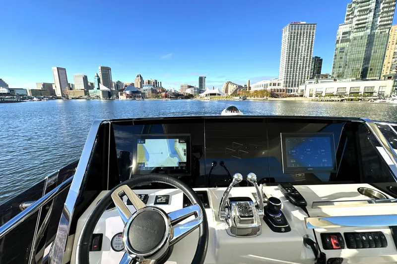 Highland Patriot Yacht Photos Pics Cockpit view of 2023 Prestige 590 yacht with city skyline in background.