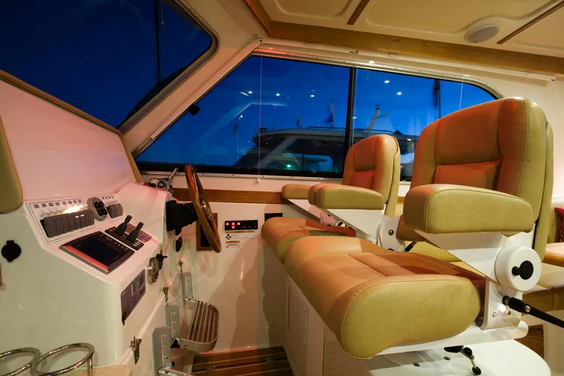  Yacht Photos Pics 2026 Back Cove 372 boat interior with helm station and two cushioned seats.