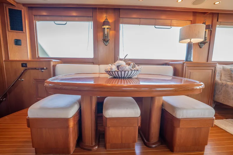 Beba Yacht Photos Pics Luxurious dining area on a 2003 Fleming 75 yacht with elegant wooden table and cushioned seating.