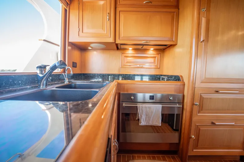 Beba Yacht Photos Pics Luxurious wooden kitchen interior on a 2003 Fleming 75 yacht, featuring modern appliances.
