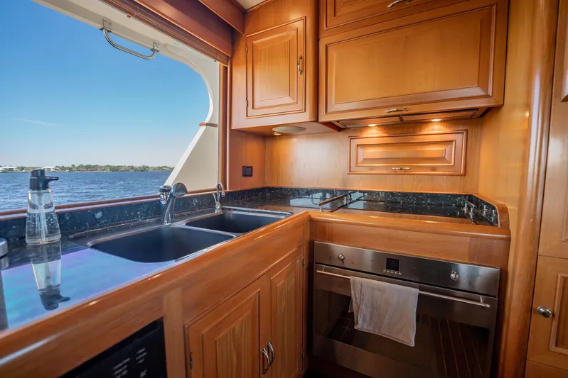 Beba Yacht Photos Pics Luxurious kitchen interior on a 2003 Fleming 75 yacht with wood cabinetry and ocean view.