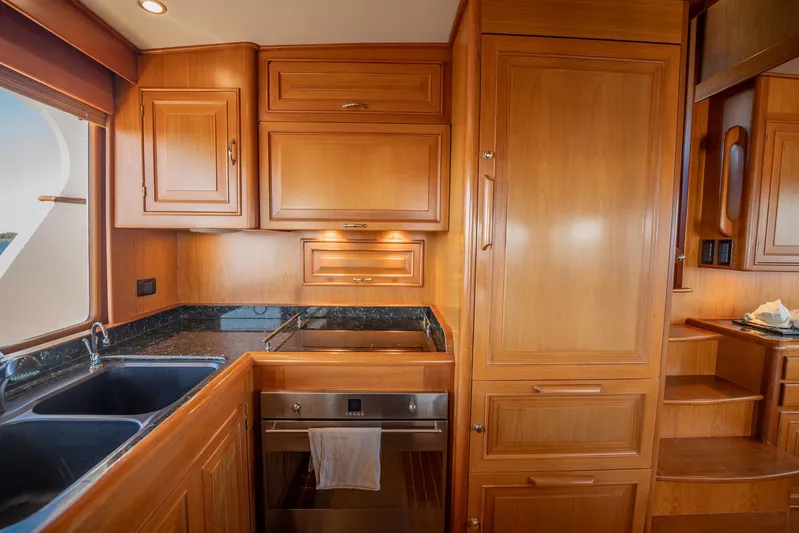 Beba Yacht Photos Pics Luxurious wooden kitchen interior on a 2003 Fleming 75 yacht, featuring modern appliances.