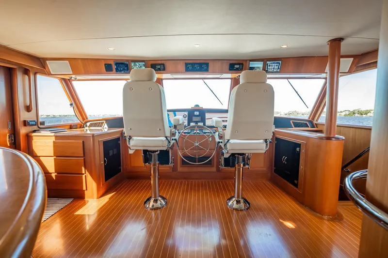 Beba Yacht Photos Pics Pilothouse interior of 2003 Fleming 75 yacht with dual captain chairs and wooden finish.
