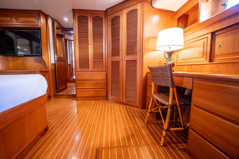 Beba Yacht Photos Pics Luxurious wooden interior of a 2003 Fleming 75 yacht cabin with desk and lamp.