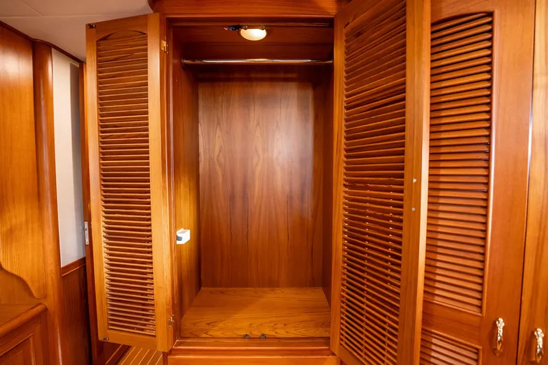 Beba Yacht Photos Pics Wooden closet interior on a 2003 Fleming 75 yacht, featuring louvered doors.