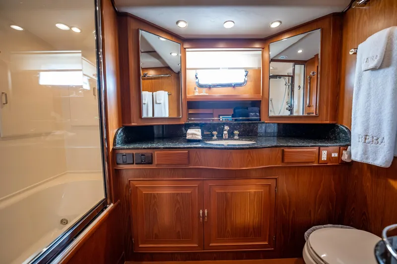 Beba Yacht Photos Pics Luxurious bathroom in a 2003 Fleming 75 yacht with wood cabinetry and elegant fixtures.