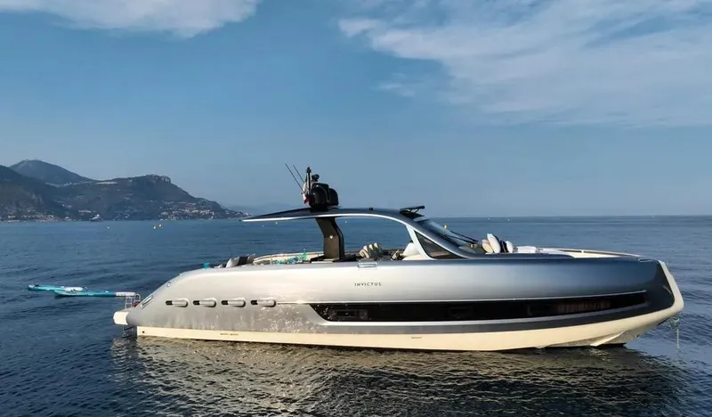 Montenegrina Yacht Photos Pics 2023 Invictus TT460 yacht on calm sea with scenic mountain backdrop.