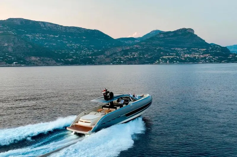 Montenegrina Yacht Photos Pics 2023 Invictus TT460 yacht cruising on serene waters with mountainous backdrop.