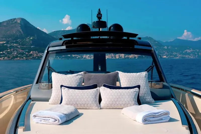 Montenegrina Yacht Photos Pics Invictus TT460 yacht 2023, luxurious deck with cushions and towels, scenic ocean view.