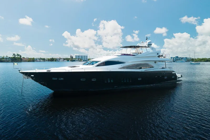 Sukha Yacht Photos Pics Luxury 2008 Sunseeker 90 Yacht on calm water under clear blue sky.