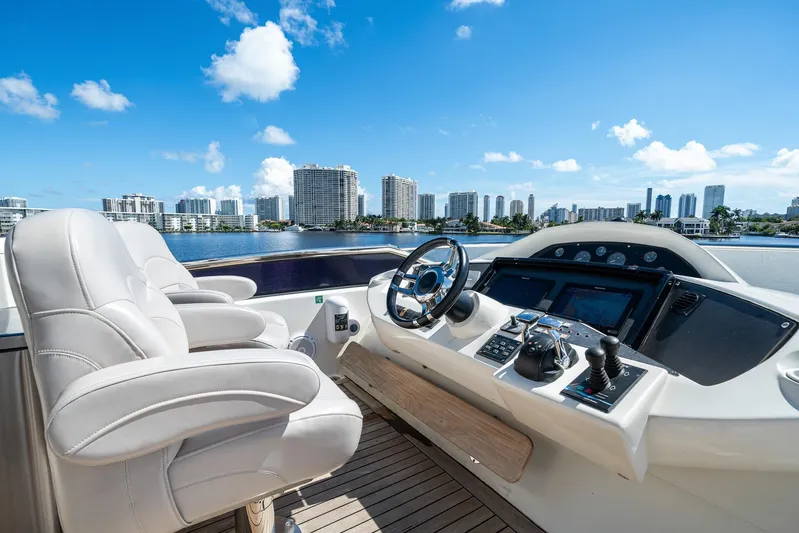 Sukha Yacht Photos Pics Luxurious 2008 Sunseeker 90 Yacht helm with city skyline view.
