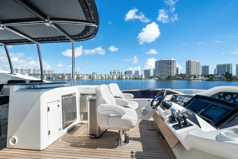 Sukha Yacht Photos Pics Luxurious 2008 Sunseeker 90 Yacht helm with city skyline view.