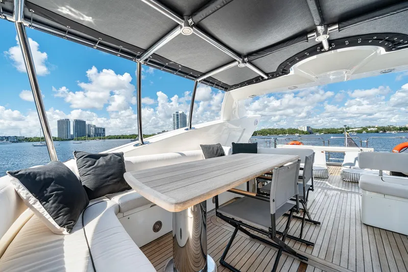 Sukha Yacht Photos Pics Luxurious 2008 Sunseeker 90 Yacht deck with seating, table, and scenic waterfront view.
