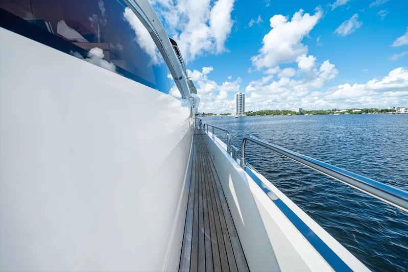 Sukha Yacht Photos Pics Side view of 2008 Sunseeker 90 Yacht on water, clear sky, and distant buildings.