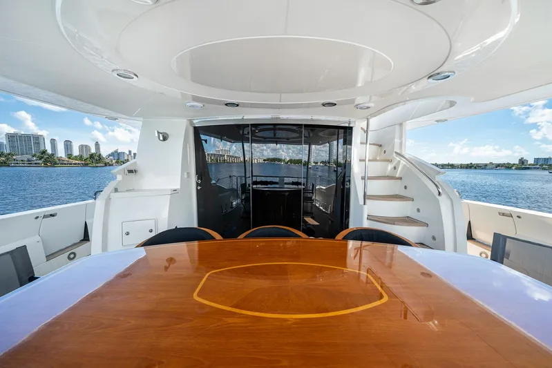 Sukha Yacht Photos Pics Luxurious 2008 Sunseeker 90 Yacht deck with elegant dining area and scenic waterfront view.