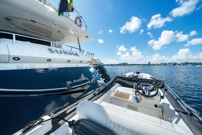 Sukha Yacht Photos Pics 2008 Sunseeker 90 Yacht "Sukha" docked in St. Ann's Bay, with a small boat nearby.