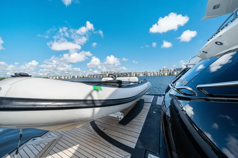 Sukha Yacht Photos Pics 2008 Sunseeker 90 Yacht with inflatable boat on deck, under a clear blue sky.