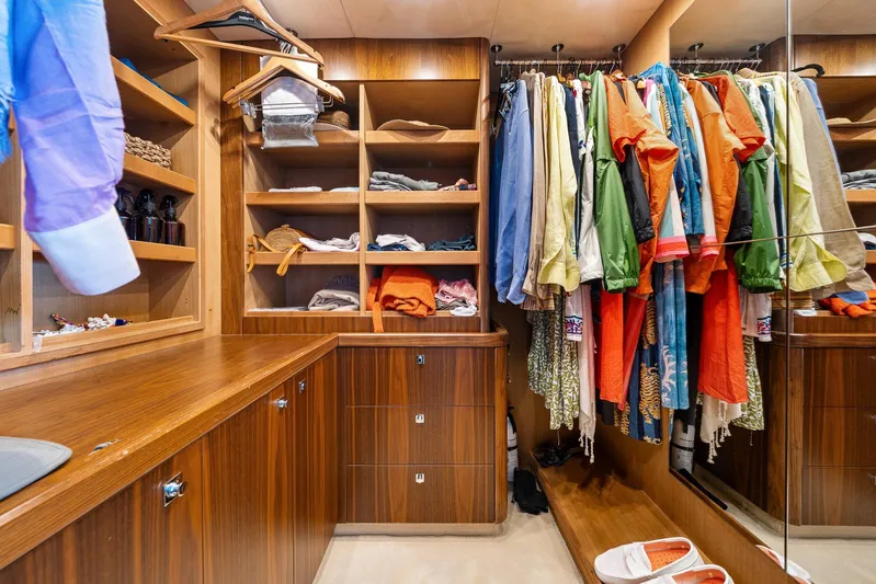 Sukha Yacht Photos Pics Luxurious wooden closet with colorful clothes in a 2008 Sunseeker 90 Yacht.