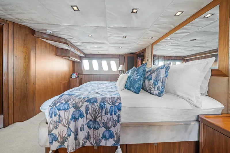 Sukha Yacht Photos Pics Luxurious bedroom interior of 2008 Sunseeker 90 Yacht with floral bedding and wood paneling.