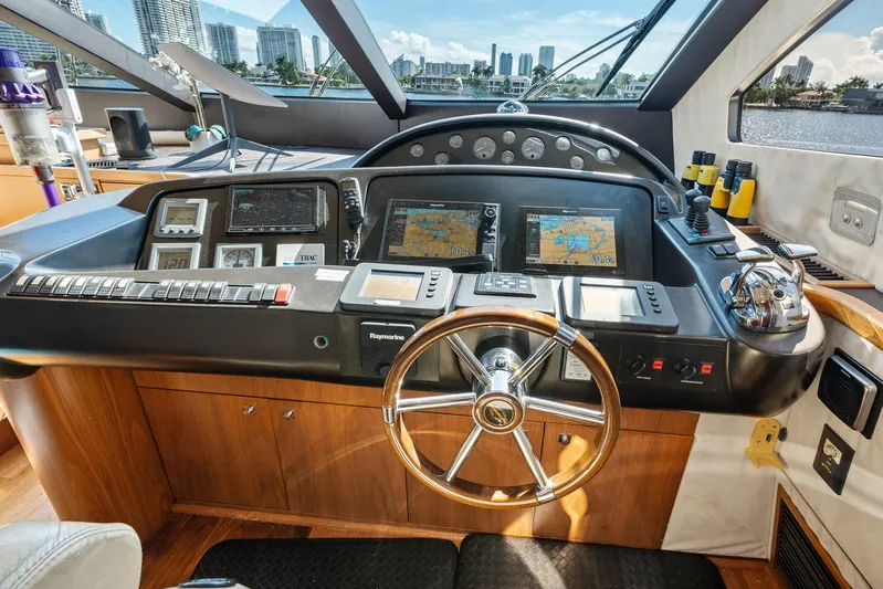 Sukha Yacht Photos Pics Helm of 2008 Sunseeker 90 Yacht with navigation equipment and city skyline view.