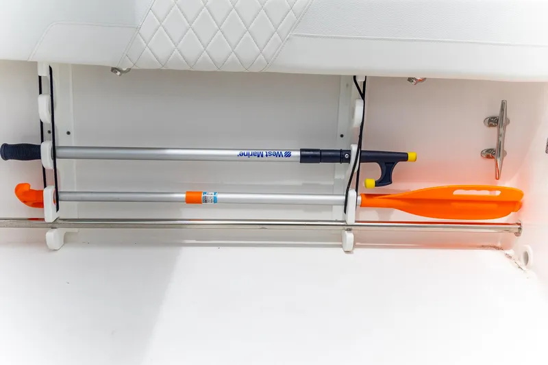  Yacht Photos Pics Storage compartment in 2023 Edgewater 248 CX boat with paddle and boat hook.