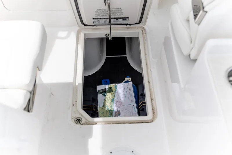  Yacht Photos Pics Storage compartment in 2023 Edgewater 248 CX boat with nautical charts and equipment.