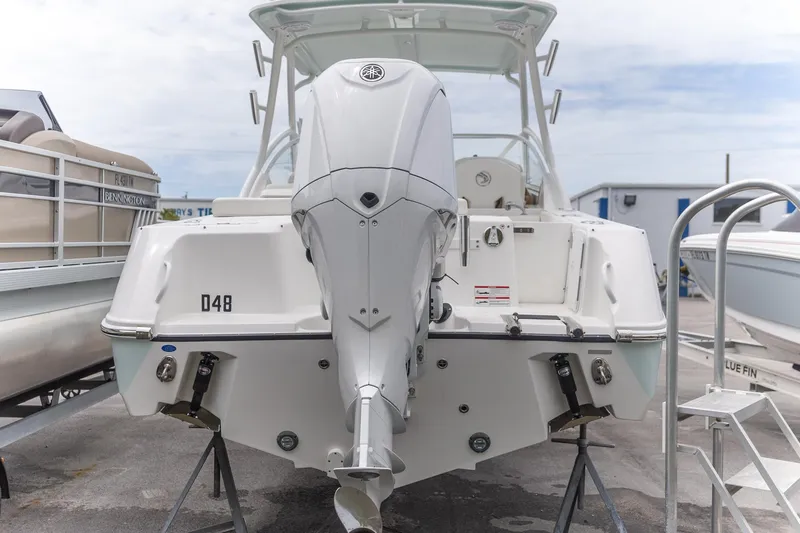  Yacht Photos Pics 2023 Edgewater 248 CX boat, rear view with outboard motor, docked on a trailer.