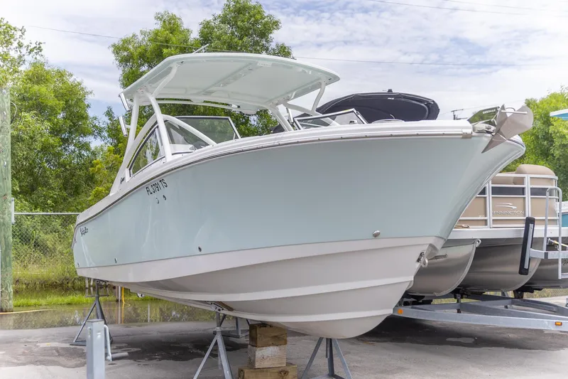  Yacht Photos Pics 2023 Edgewater 248 CX boat on display, surrounded by greenery.