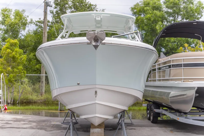  Yacht Photos Pics 2023 Edgewater 248 CX boat displayed outdoors, front view, with trees in the background.