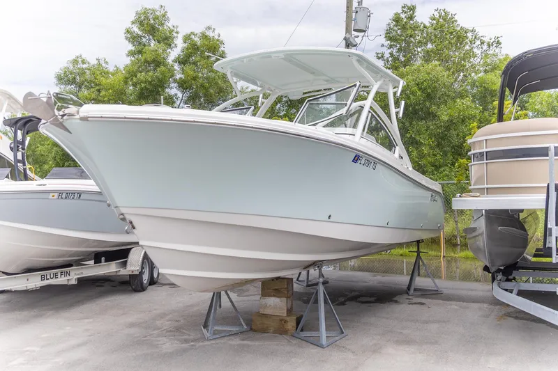  Yacht Photos Pics 2023 Edgewater 248 CX boat on display, surrounded by trees and other boats.