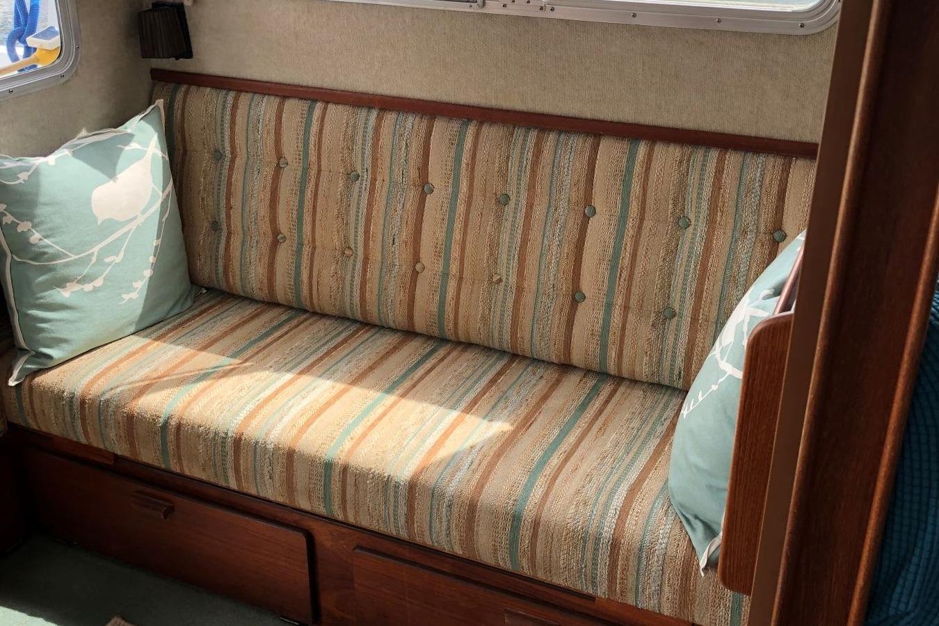 Vintage 1988 Commander 30 Command Bridge interior with striped sofa and decorative pillows.