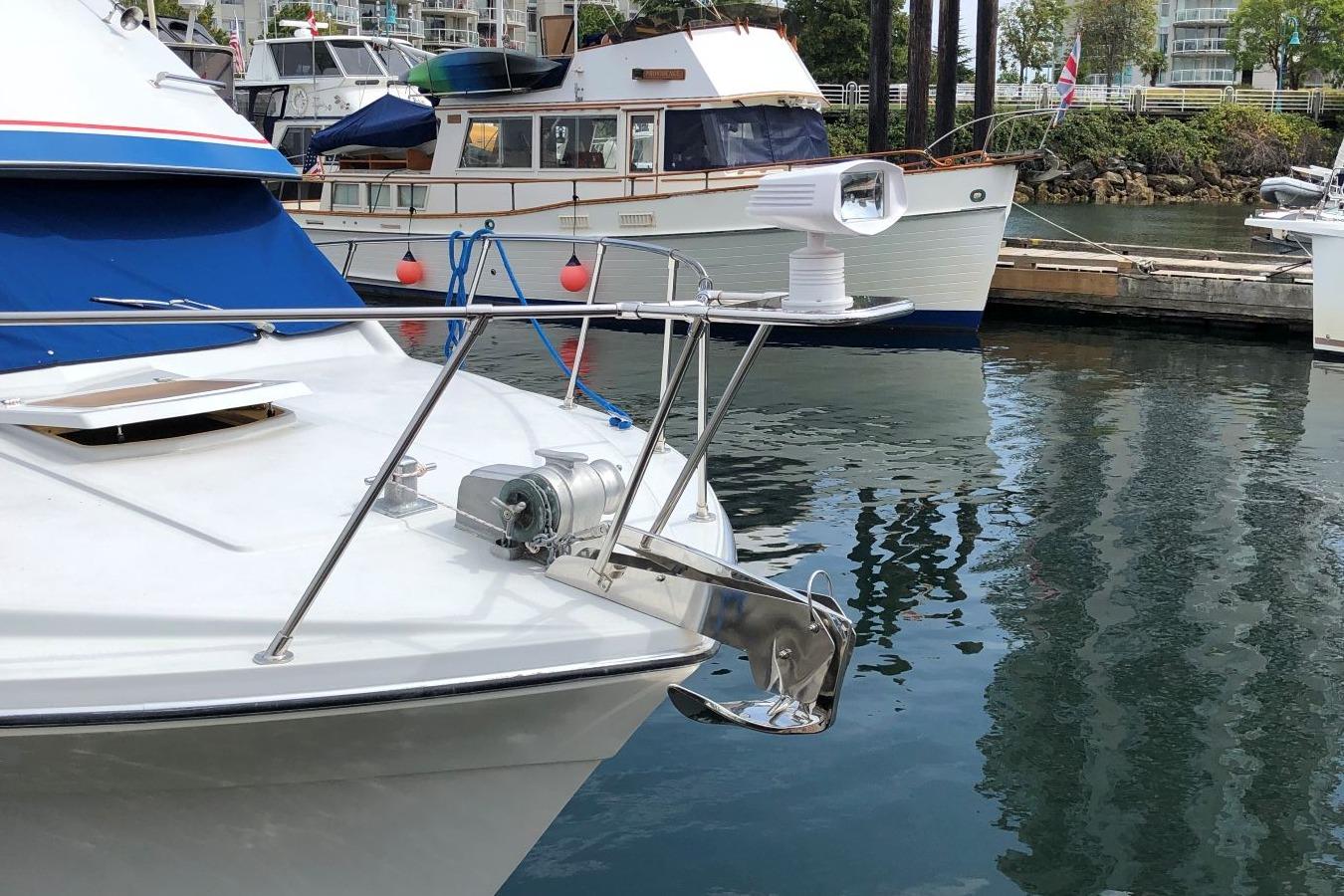 1988 Commander 30 Command Bridge yacht docked, featuring anchor and spotlight.