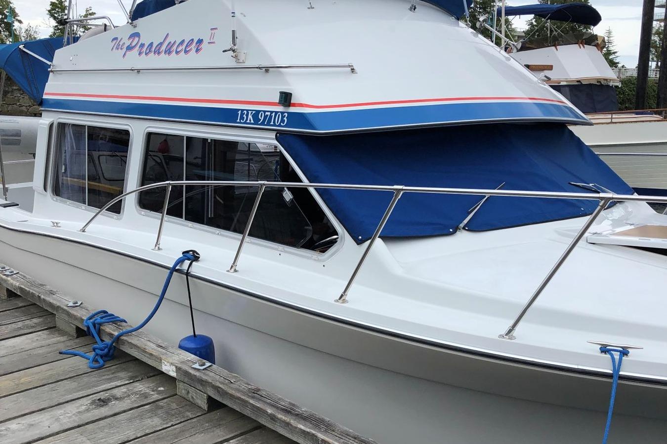 1988 Commander 30 Command Bridge boat docked with blue canopy and railing.