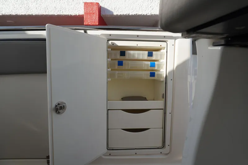  Yacht Photos Pics 2015 MTI 42 XSF boat storage compartment with open door and organized shelves.