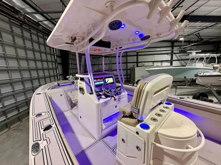  Yacht Photos Pics 2020 Sea Chaser 30 HFC CC boat interior with illuminated dashboard and seating in a garage.
