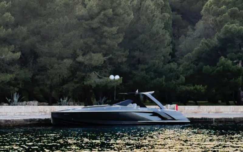  Yacht Photos Pics 2019 Frauscher 1414 Demon yacht docked by a forested shoreline.