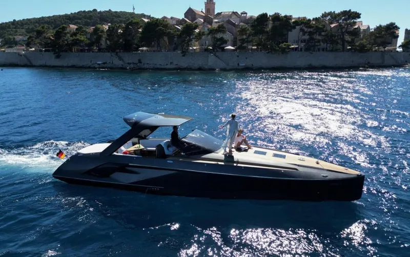  Yacht Photos Pics 2019 Frauscher 1414 Demon yacht cruising on blue waters near a scenic coastal town.