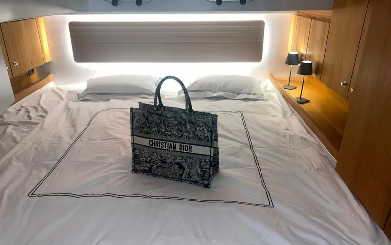  Yacht Photos Pics Luxurious cabin interior of 2019 Frauscher 1414 Demon with Christian Dior bag on bed.