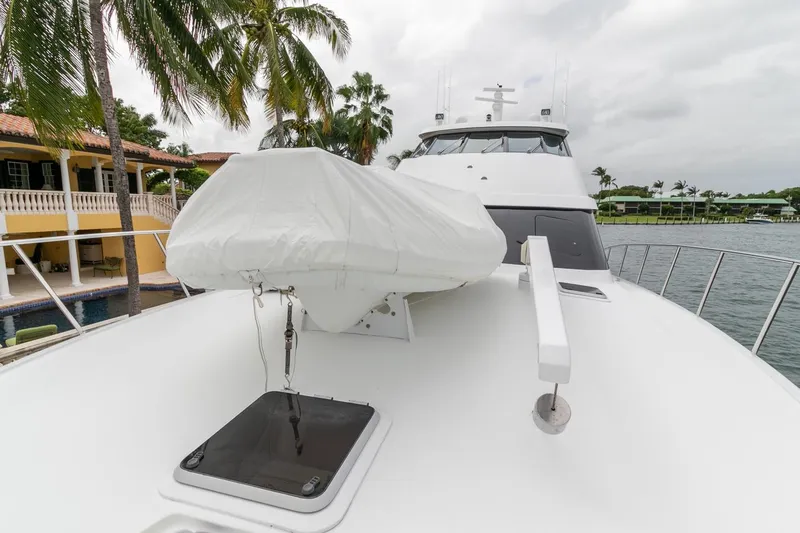 Chairman Yacht Photos Pics Palmer Johnson 80 Sportfish M/Y 1997 yacht deck with covered equipment, palm trees, and waterfront view.