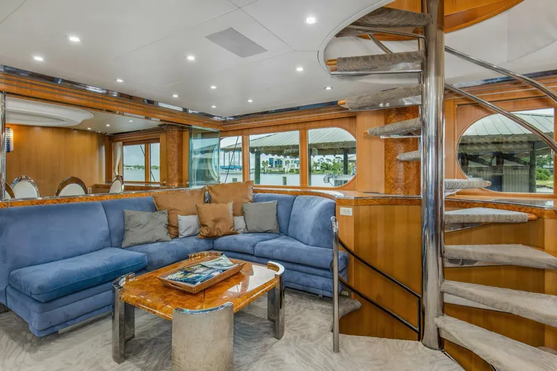 Boss Yacht Photos Pics Luxurious interior of 1989 Feadship 116 Sport Fisher yacht with spiral staircase and plush seating.