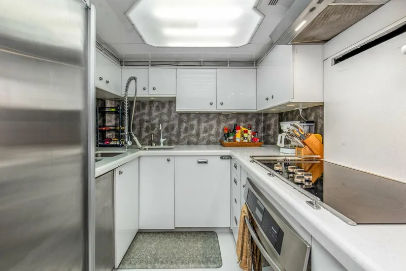 Boss Yacht Photos Pics Modern kitchen interior on 1989 Feadship 116 Sport Fisher yacht, featuring sleek white cabinetry.